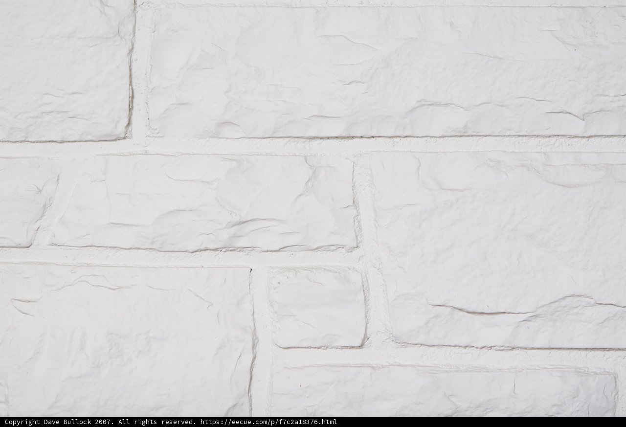 White Stone Wall with Intricate Brick Pattern