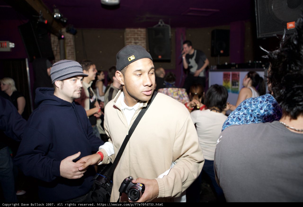 Hat-wearing Man in a Jam-Packed Nightclub