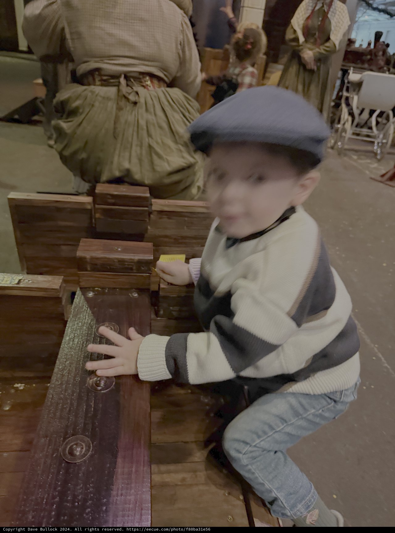 Child Explores Historical Wooden Artifacts