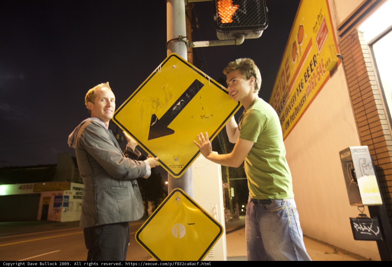 Two Men Next to a Symbolic Street Sign