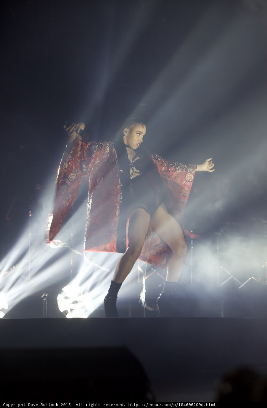 FKA twigs Full Body Dance Pose Leg Bent Microphone Red Brocade Kimono Wings Black Bodysuit Boots Light Beams