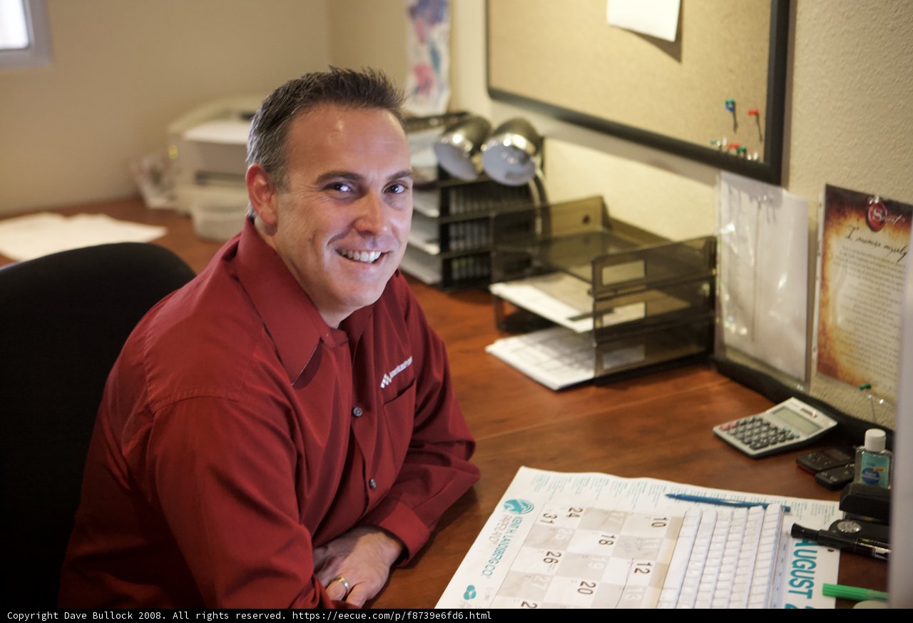 Red-Shirted Man at a Wooden Desk
