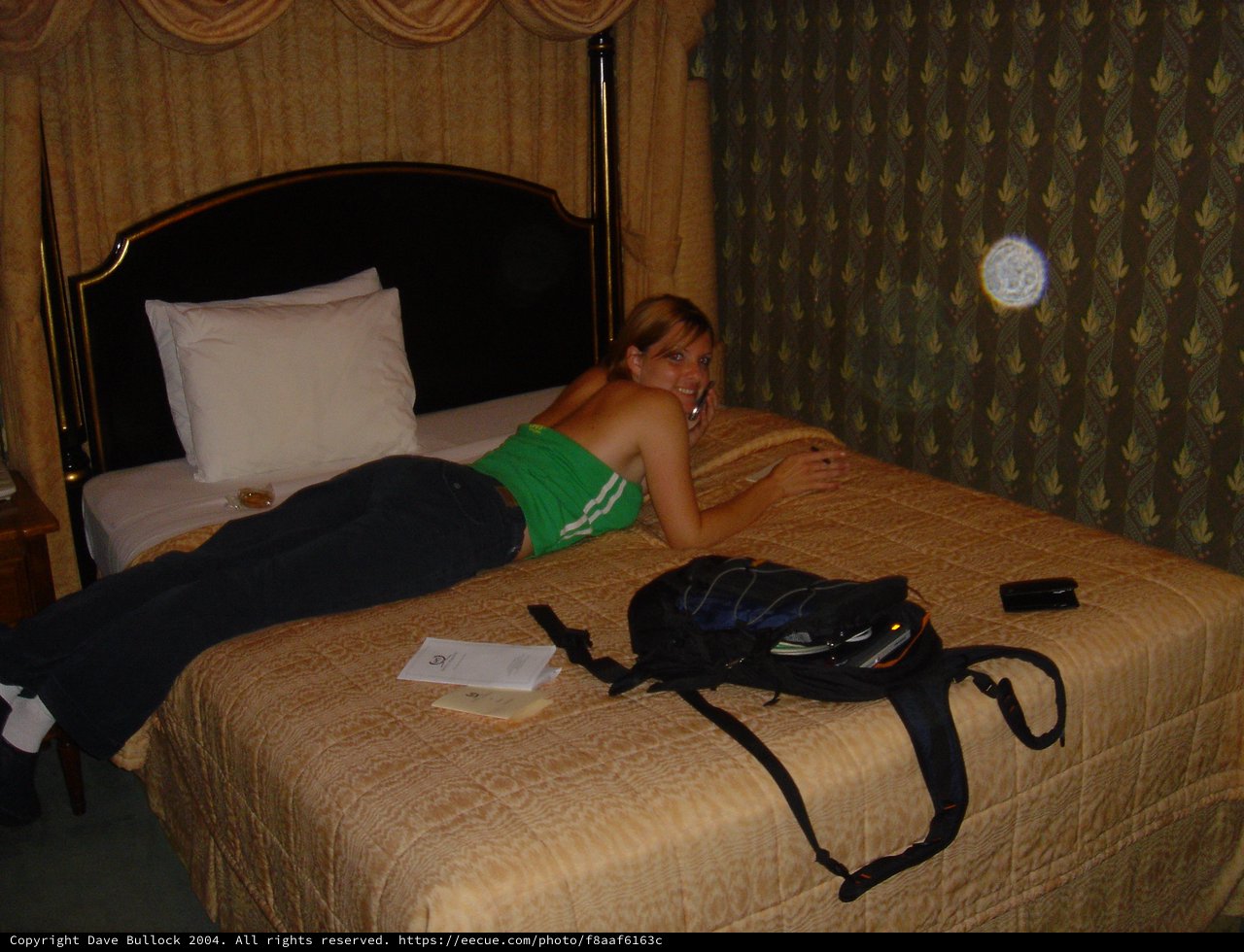 Traveler Relaxing on Hotel Bed with Backpack
