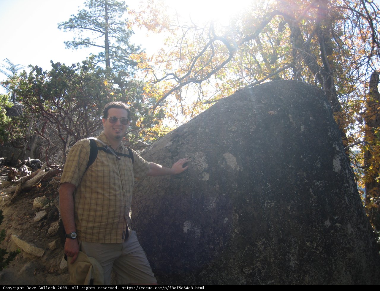 Man standing next to Rock