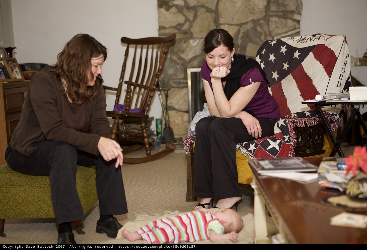 Two Women Admiring a Baby on the Floor