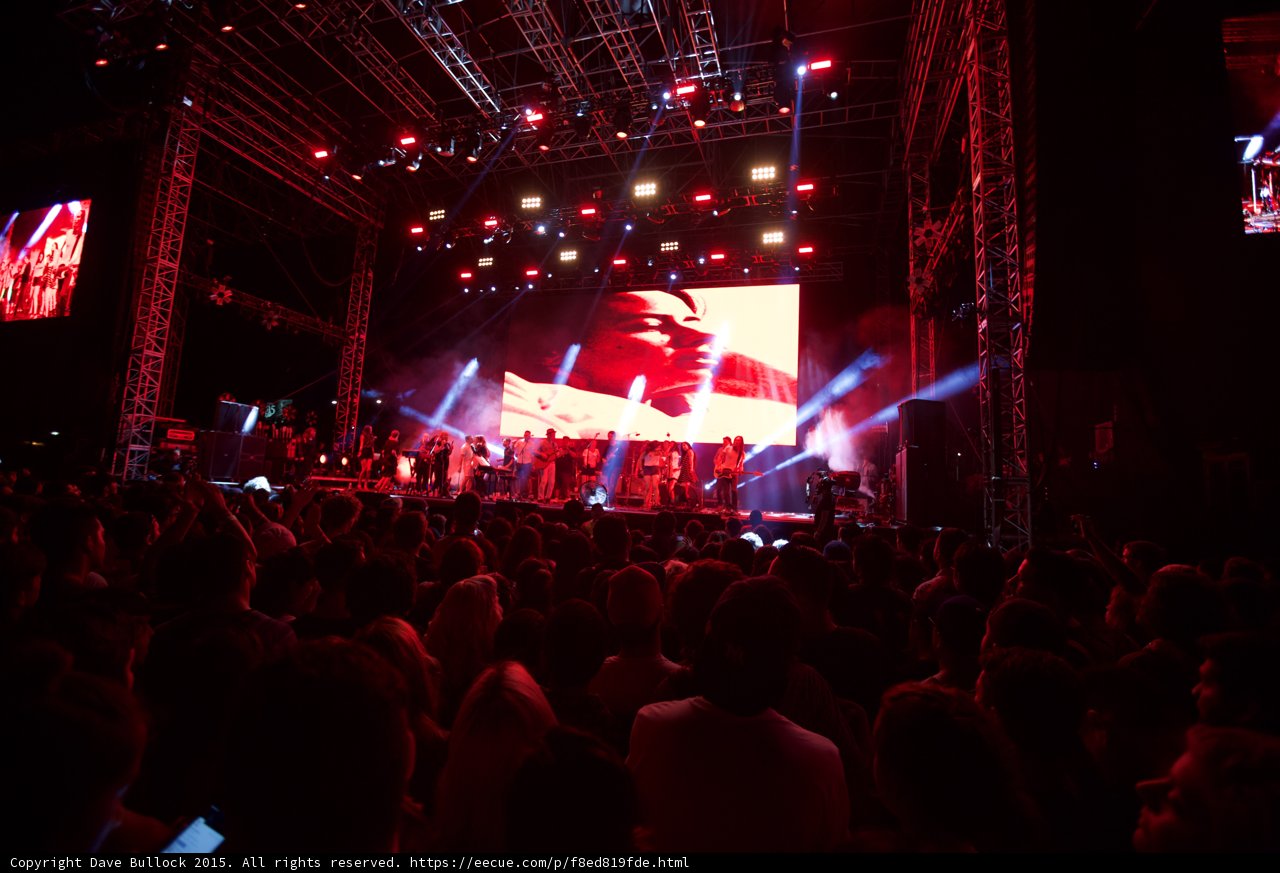 Belle and Sebastian Wide Stage Video Screens Both Sides Romantic Imagery Red Lighting Crowd