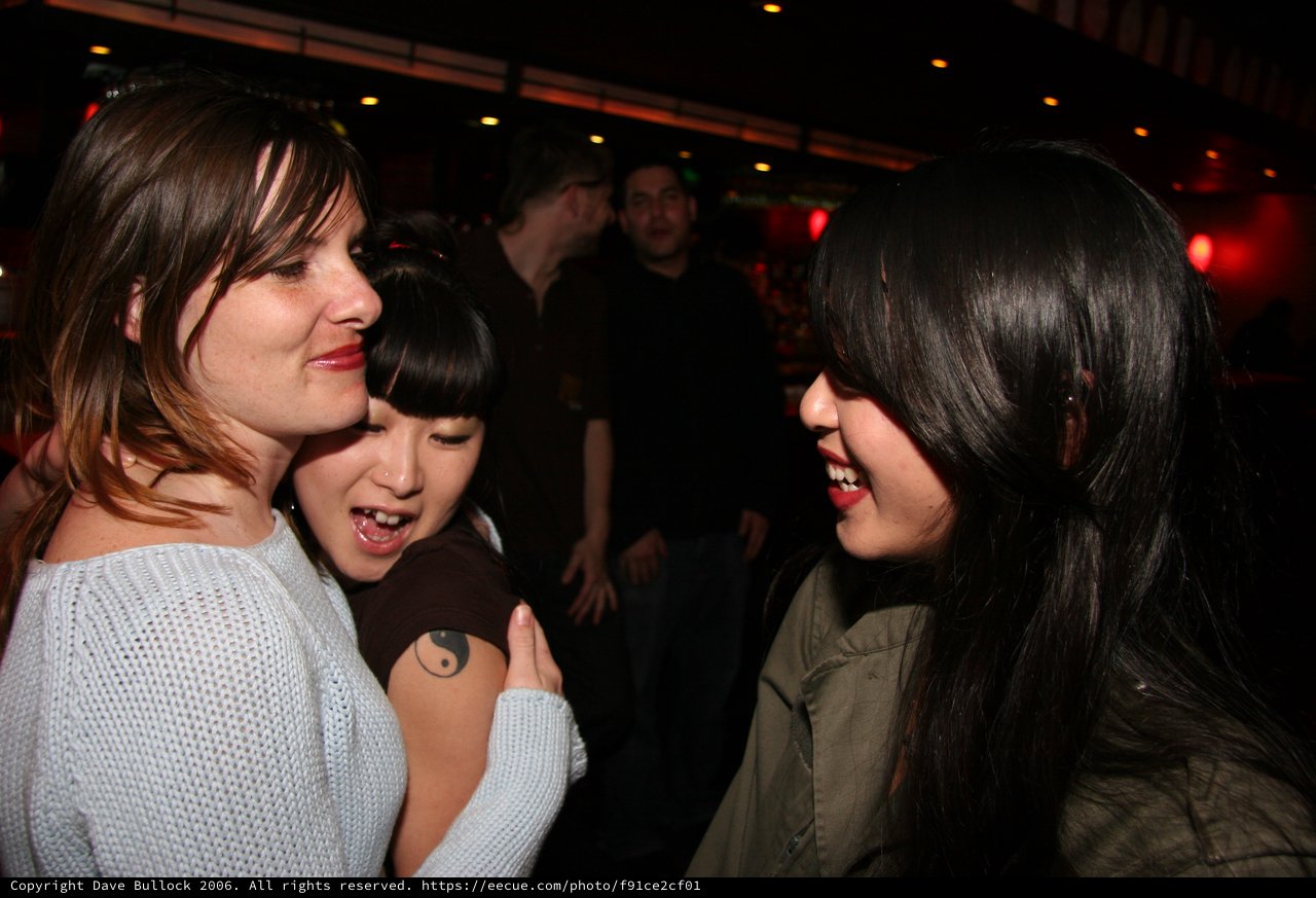 Three Friends Laughing Together at a Nightclub
