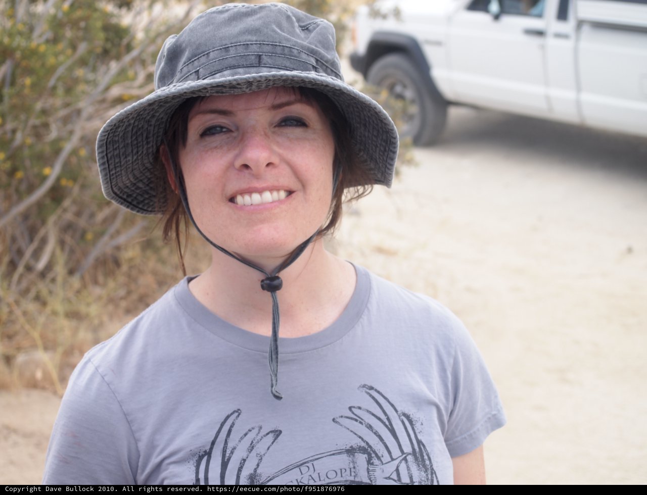 Smiling Woman in Bucket Hat at Desert Trailhead
