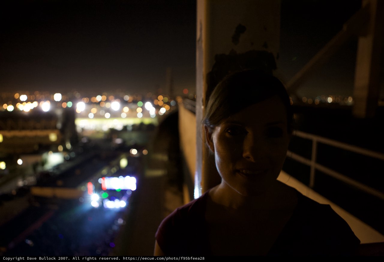 Woman in Shadow Against City Lights at Night