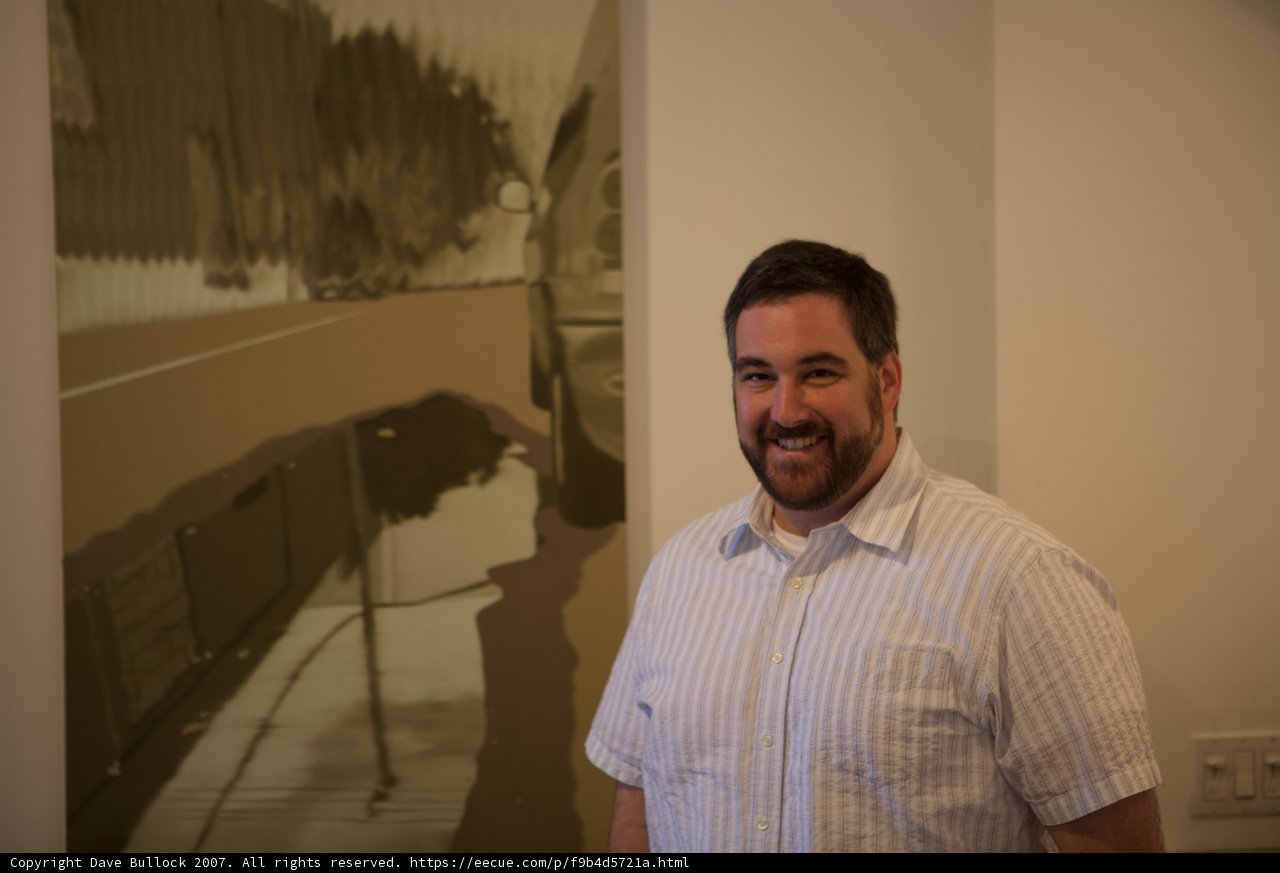 Man in White Shirt Admiring Plywood Painting