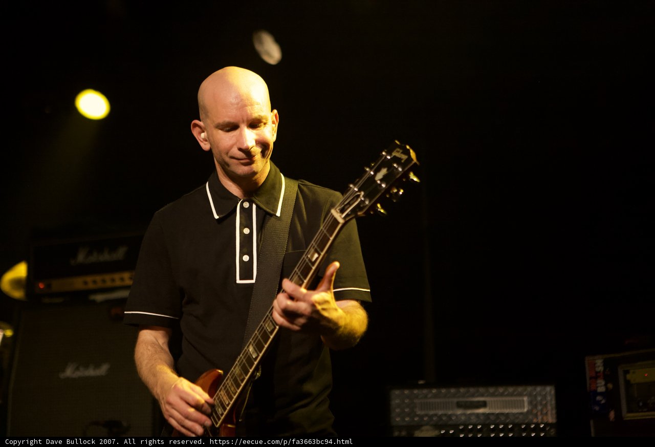 Bald Man Rocks the Stage with Electric Guitar
