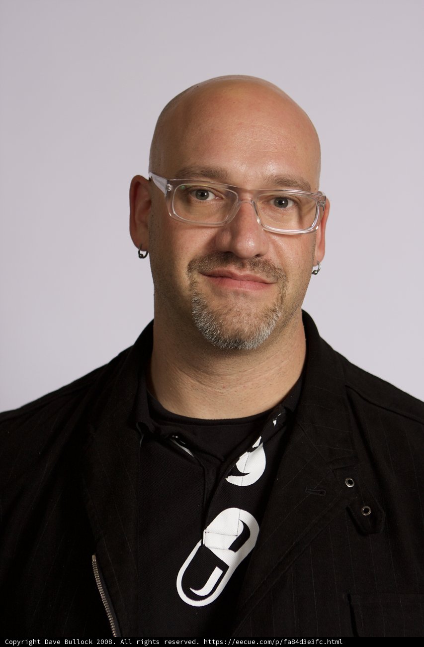 Bald man wearing glasses and a black shirt