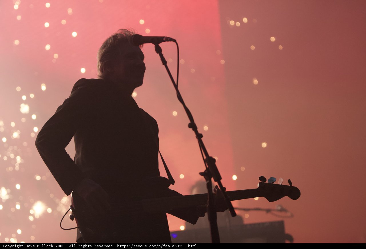 Man in a Suit Rocking the Stage with His Guitar
