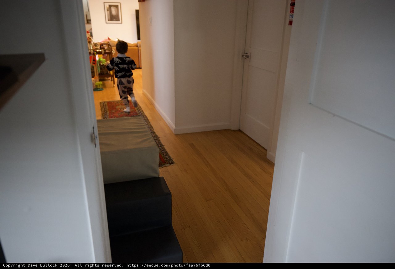 Young Child Running Through Modern Home Hallway