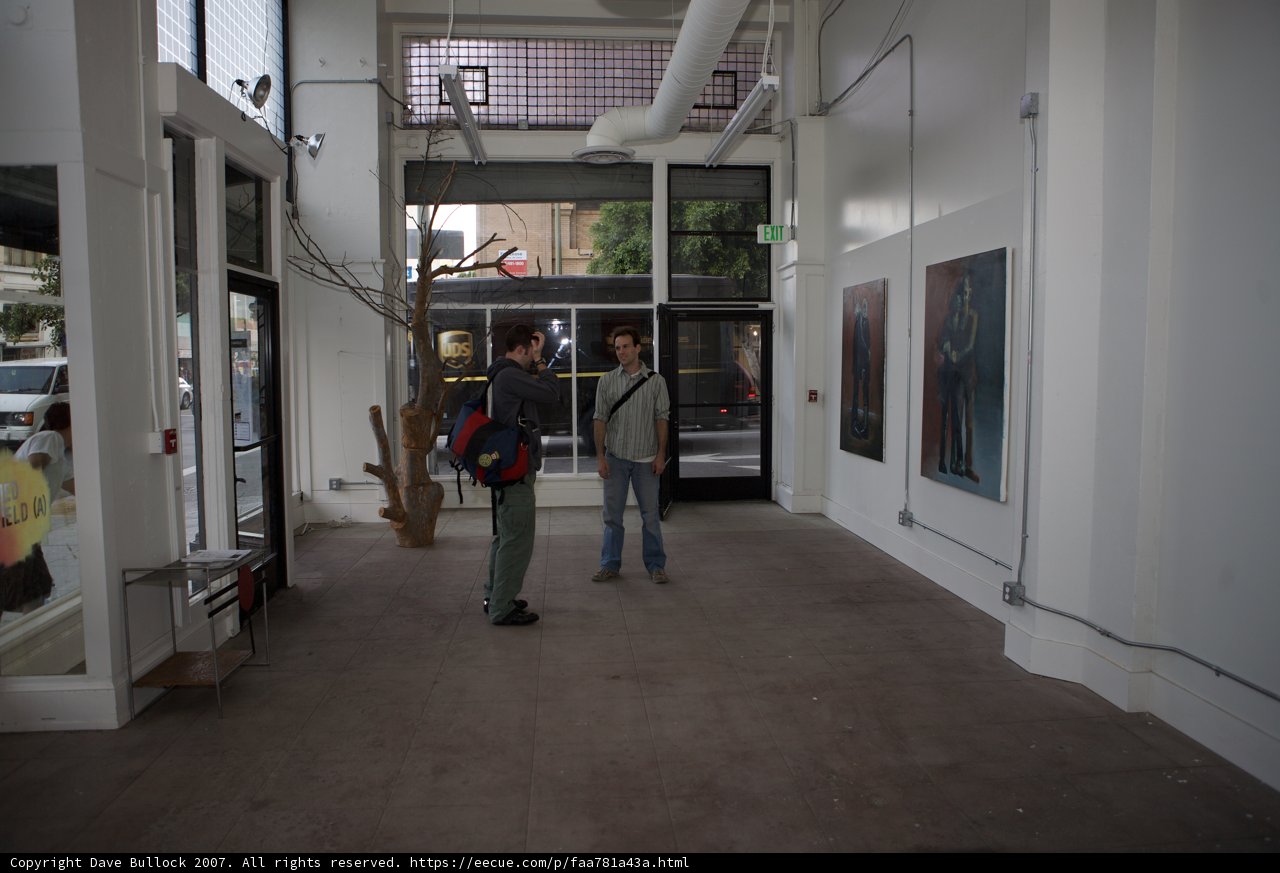 Two Men Admiring Art in Gallery Hallway