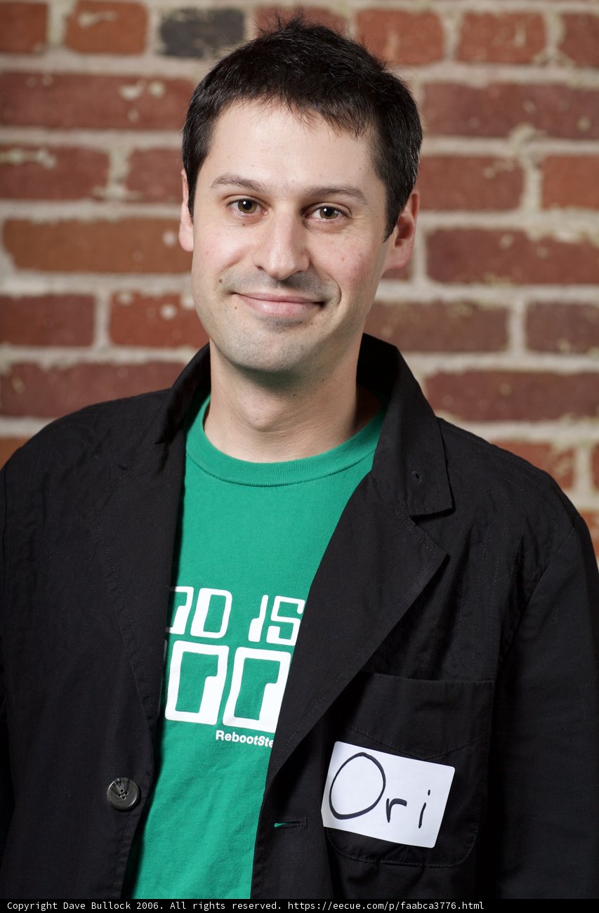 Smiling man in black coat and green shirt
