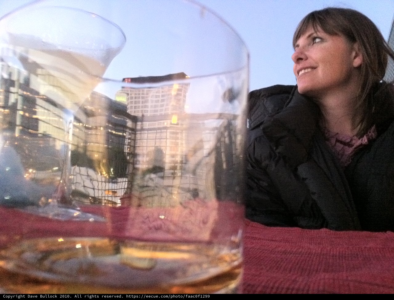 Woman Gazes at City Skyline Through Empty Glass