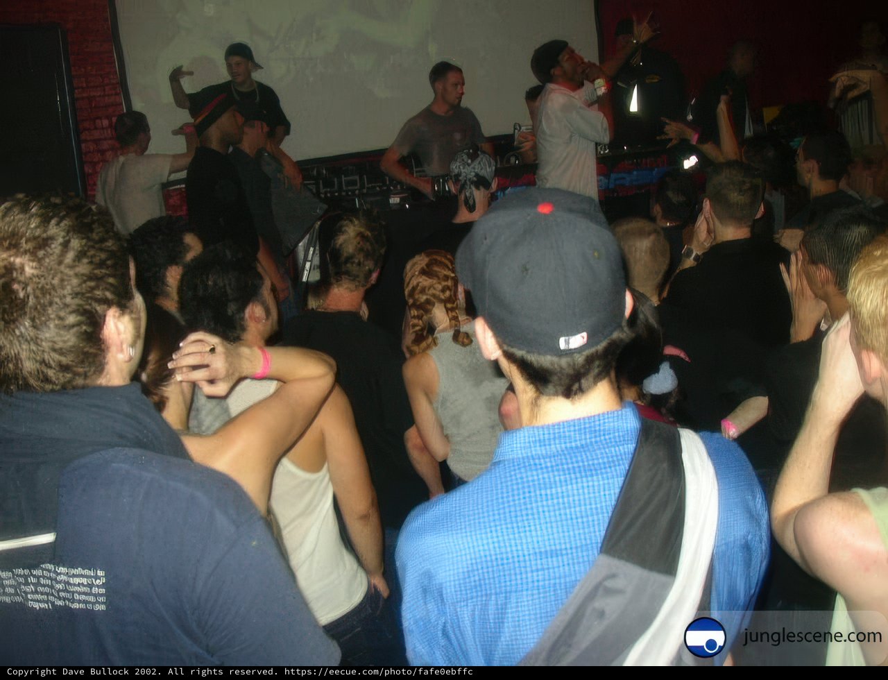 Nightclub Crowd Cheers on Man in Baseball Cap