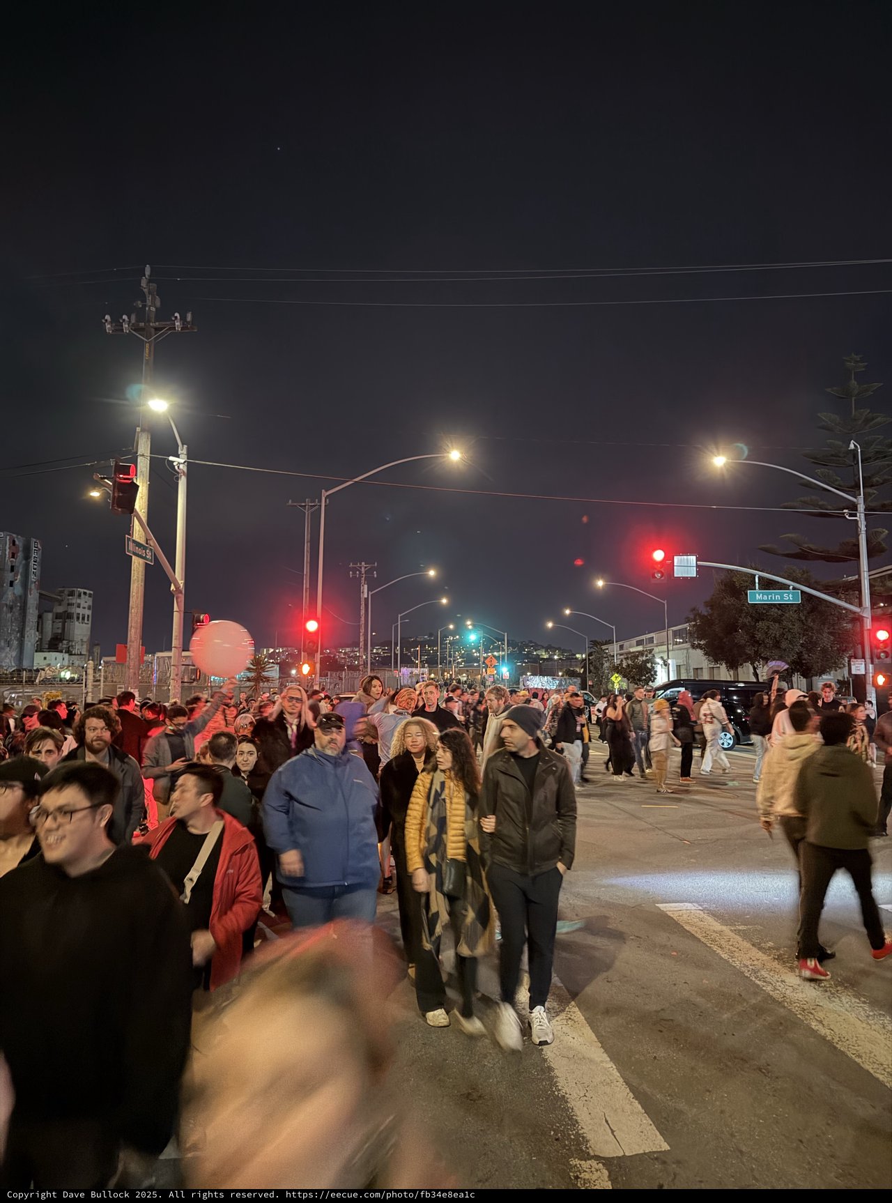 Night Street Scene with Large Crowd Gathering at Intersection