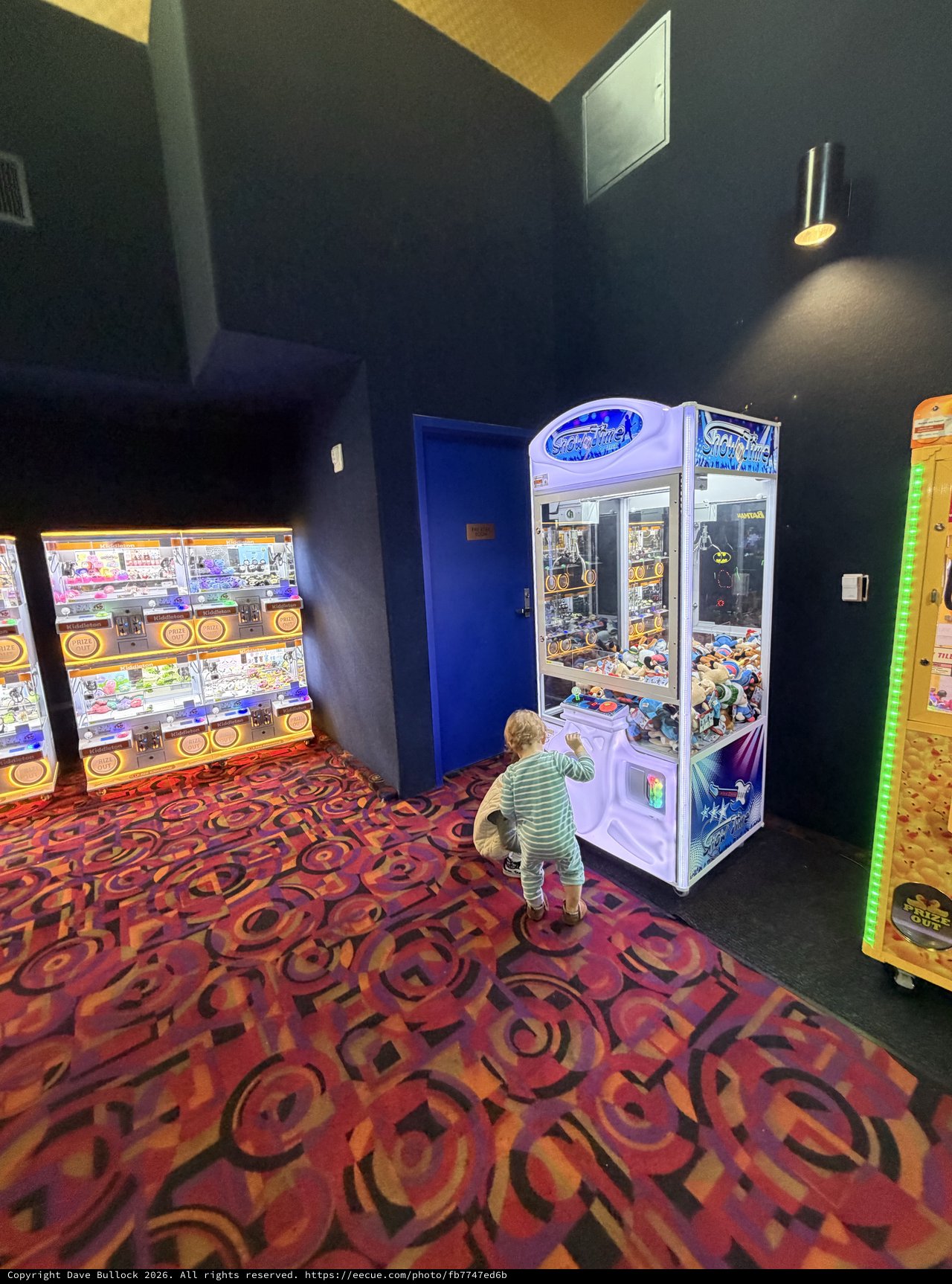 Child Playing Claw Machine at Entertainment Arcade