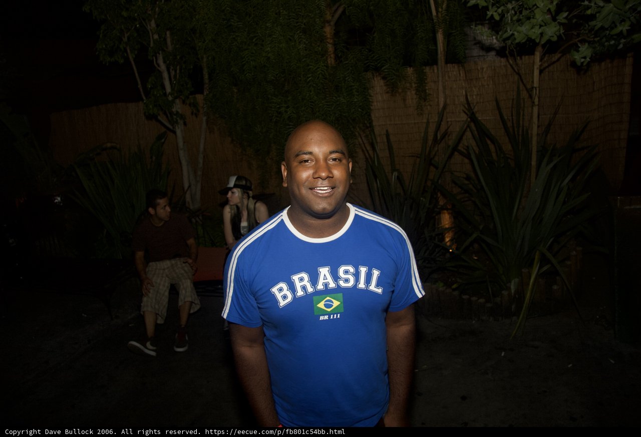 Blue Shirted Man Poses in Front of Building