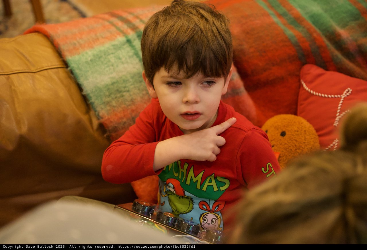 Young Boy in Christmas Pajamas Engaged with Device