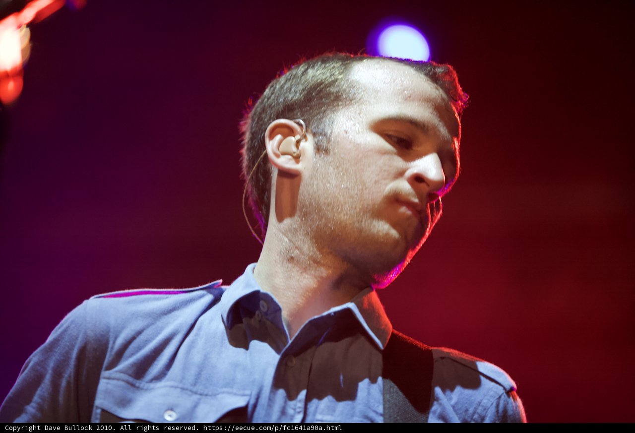 Chris Baio strums his guitar at Coachella
