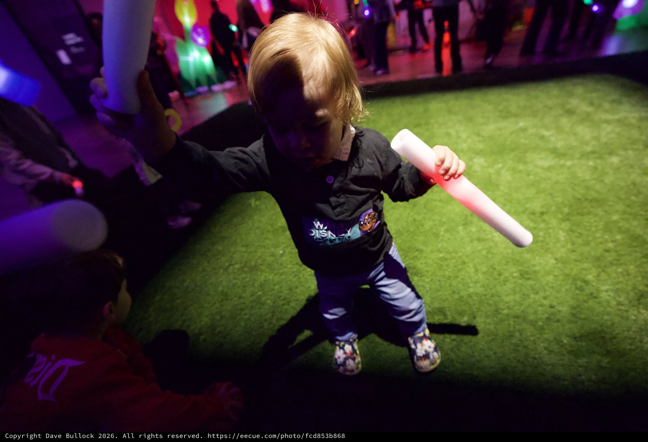 Child Dancing with Glow Stick at Baby Rave Event