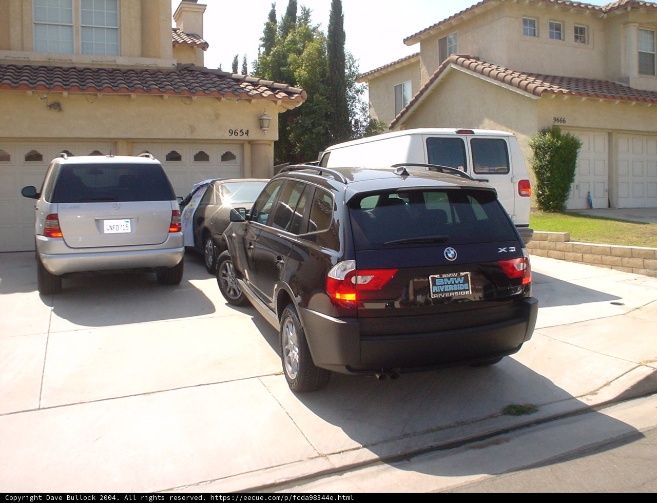 Black SUV parked in front of a single family house