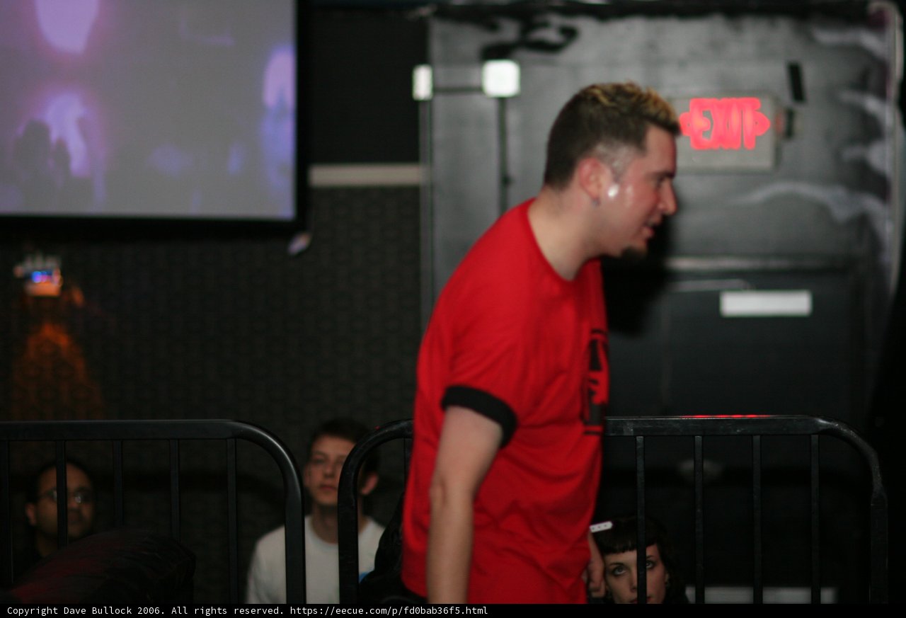 Red Shirted Man Watches Cinema on Monitor
