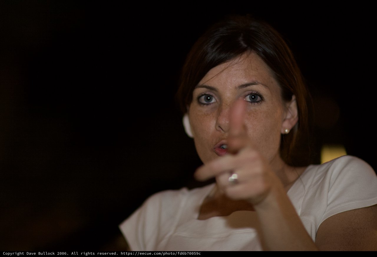 Woman Pointing with Intent in Dark Setting