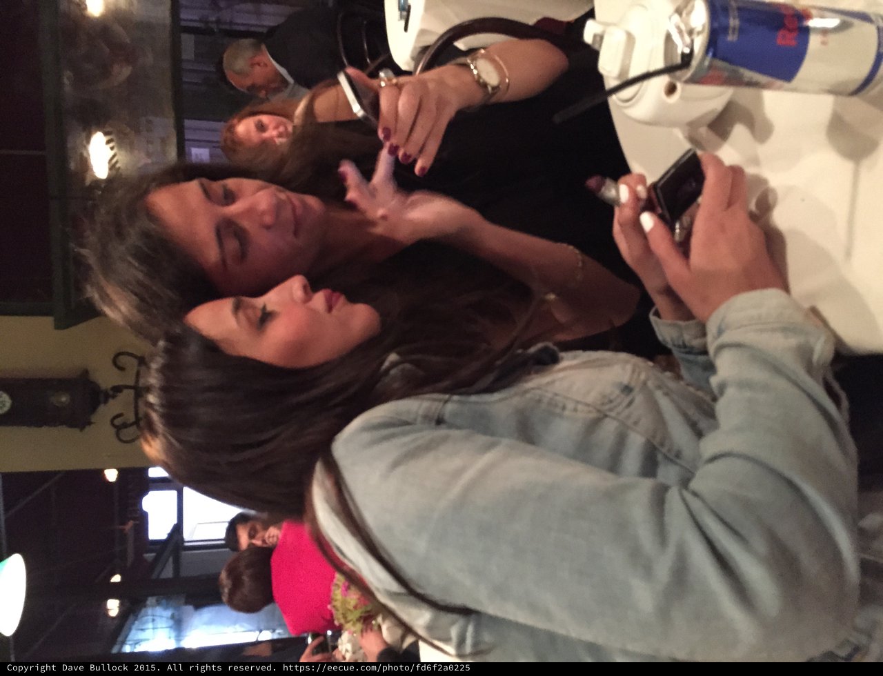 Two Friends Sharing a Moment Over Smartphones