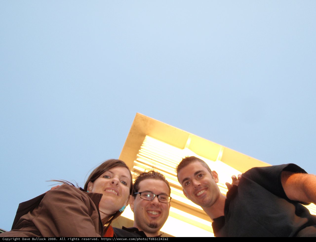 Three Friends Laugh Looking Down at Camera