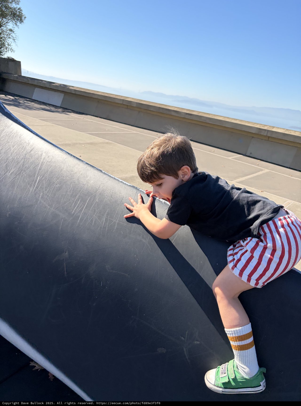 Young Boy Peering Over Urban Skateboard Ramp Edge