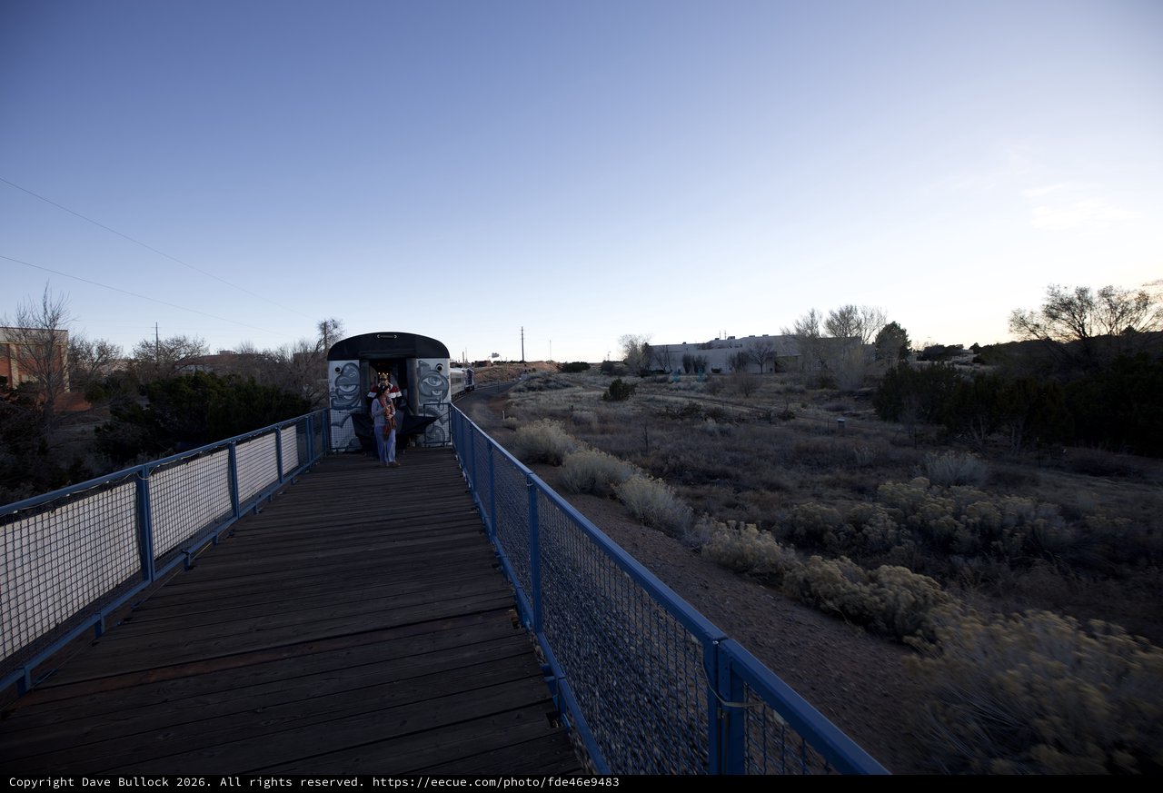 Twilight Walk on Blue Pedestrian Bridge in Desert Landscape