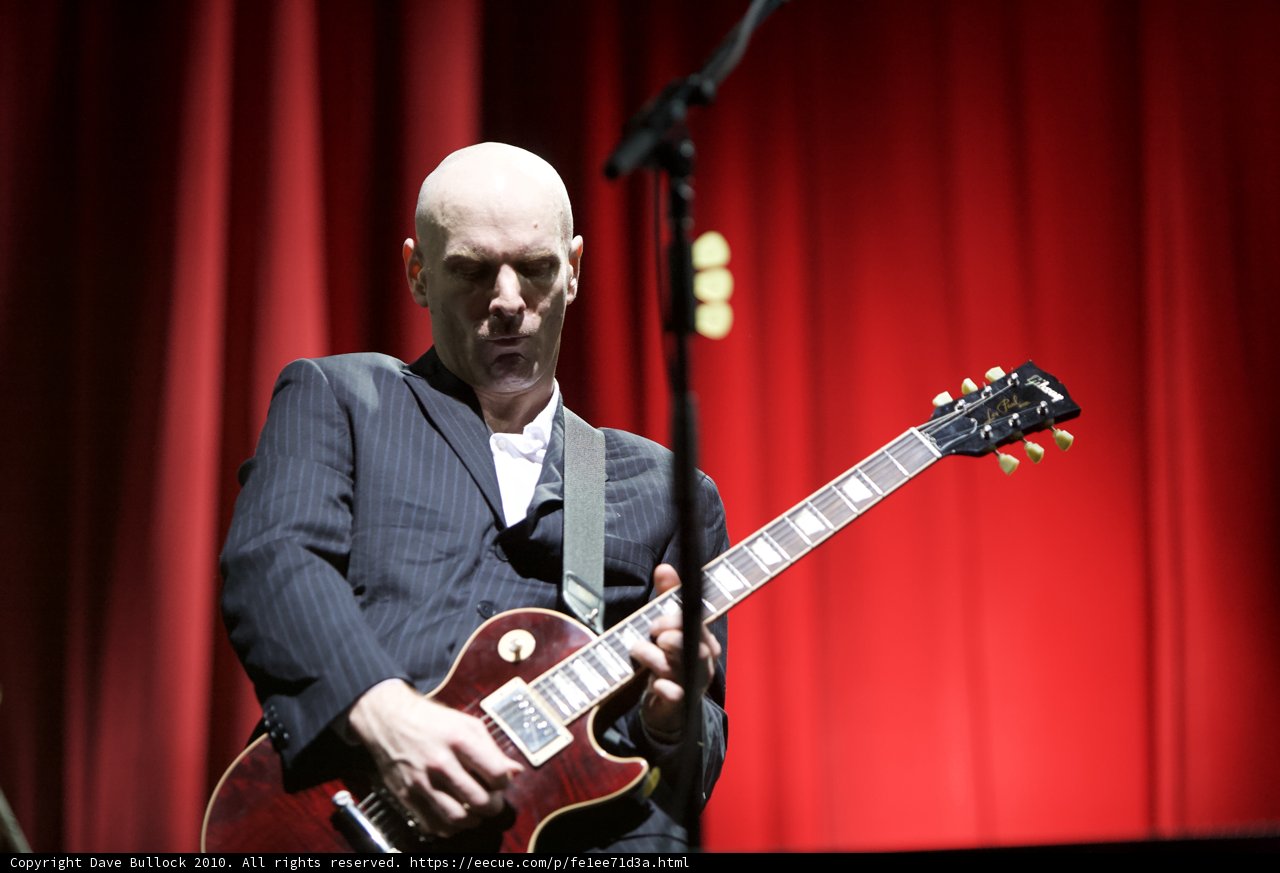 Bald Man Rocks Electric Guitar in Coachella Suit