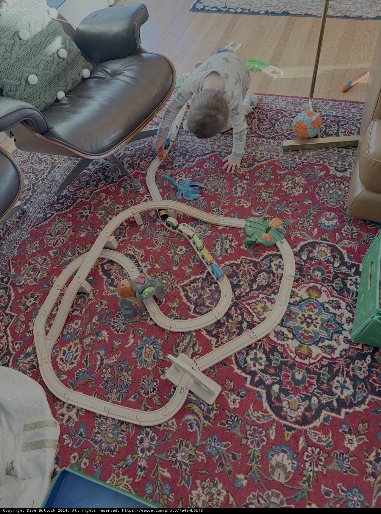 Child Playing with Train Set on Persian Rug