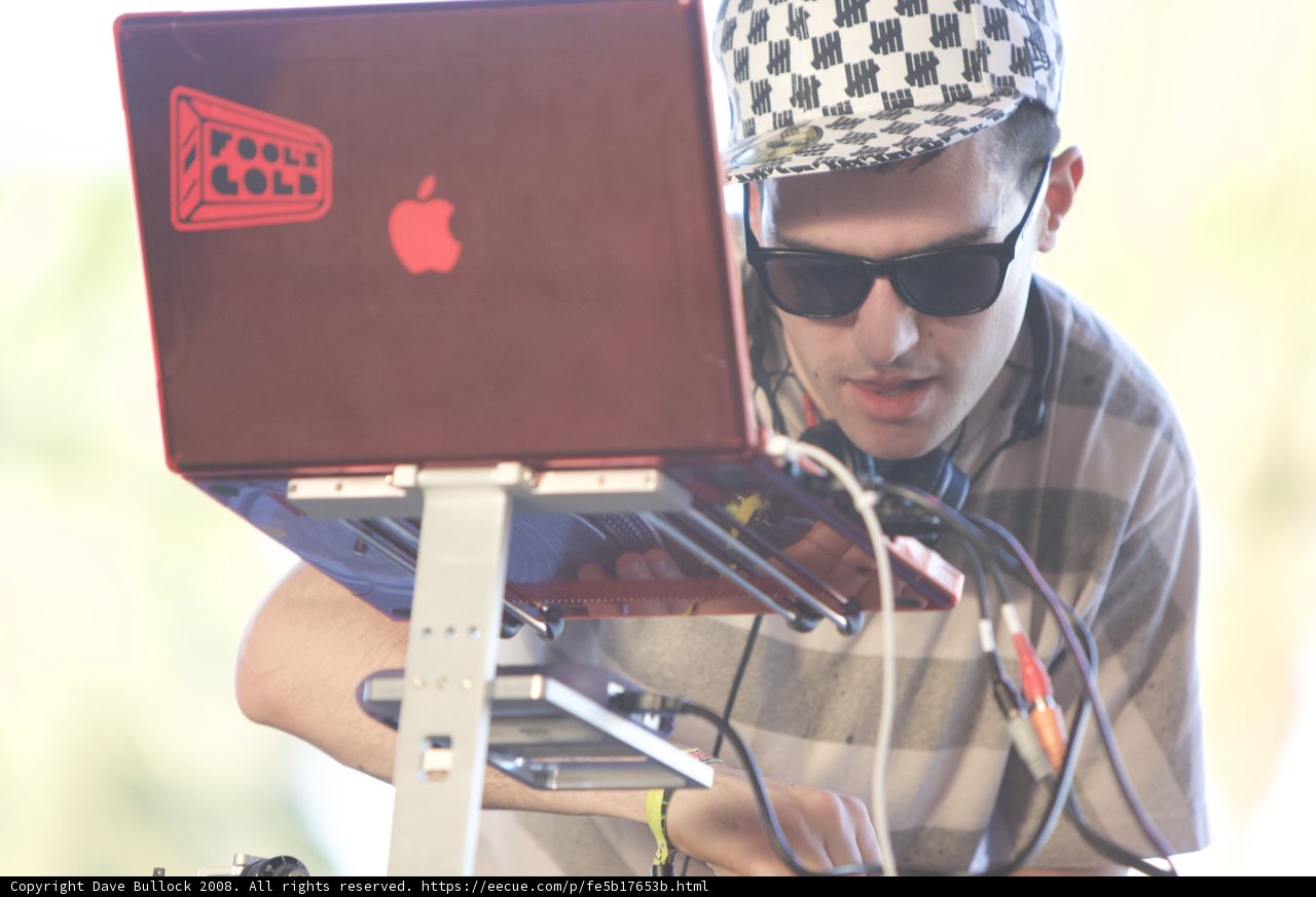 Working on the Go Caption: A man in sunglasses and a hat concentrates on his laptop at Coachella in 2008.
