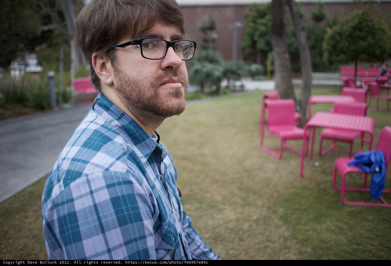 Thoughtful Man Outdoors Among Vibrant Pink Chairs