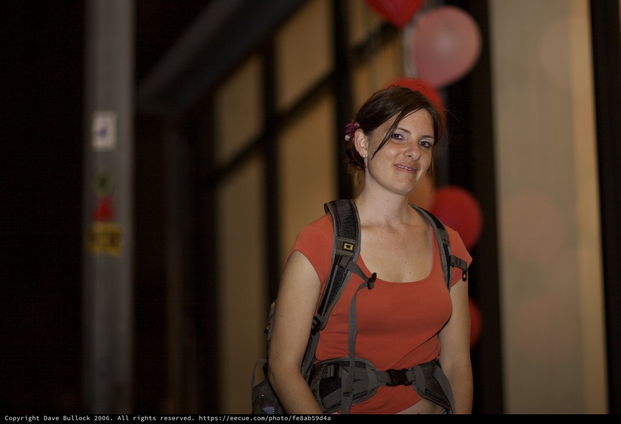 Smiling Traveler with Backpack Amid Red Balloons
