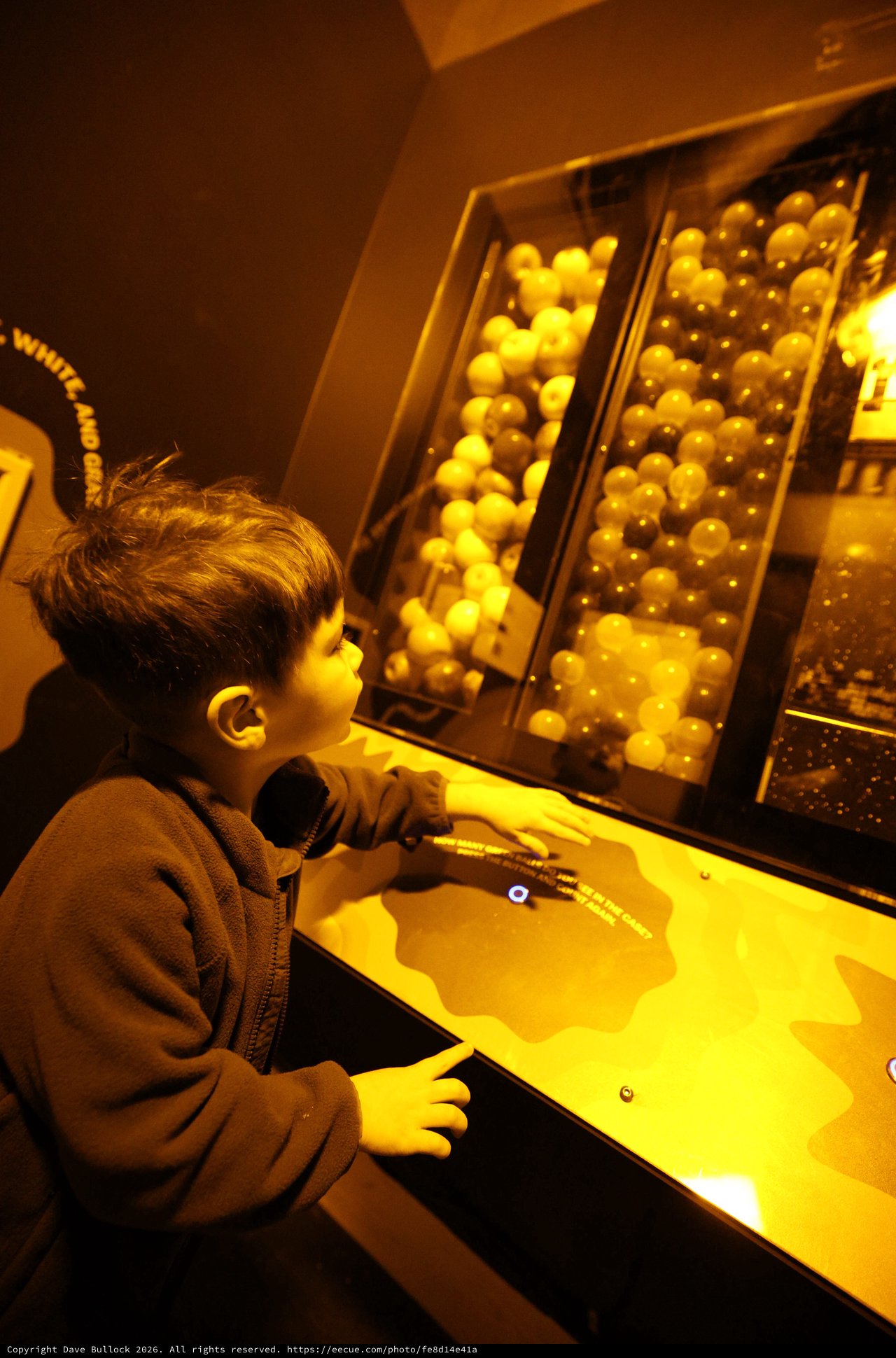 Child Exploring Interactive Ball Physics Exhibit at Science Museum