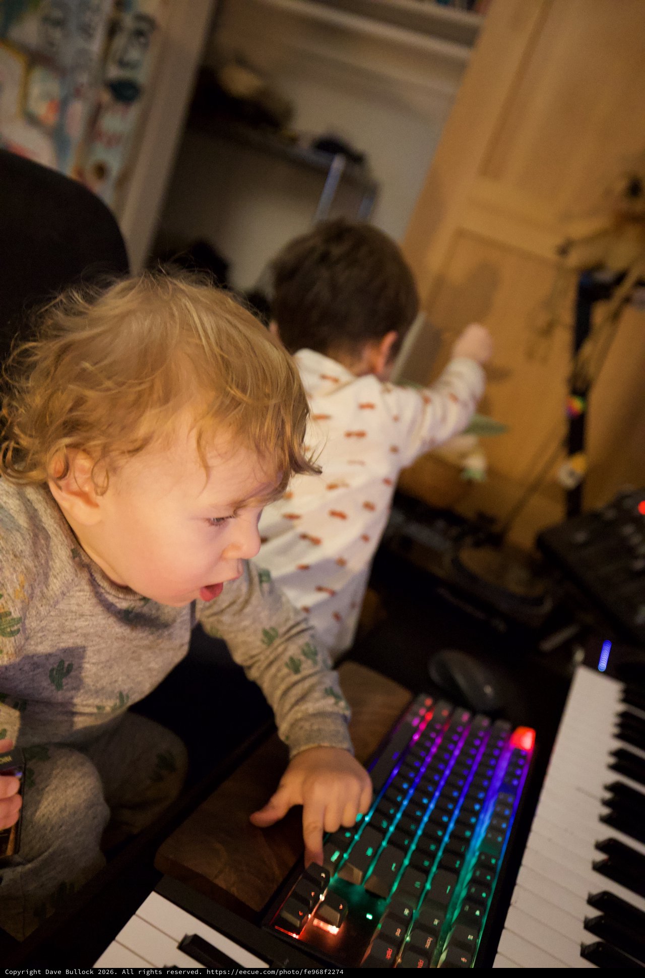 Young Child Captivated by Colorful Gaming Keyboard