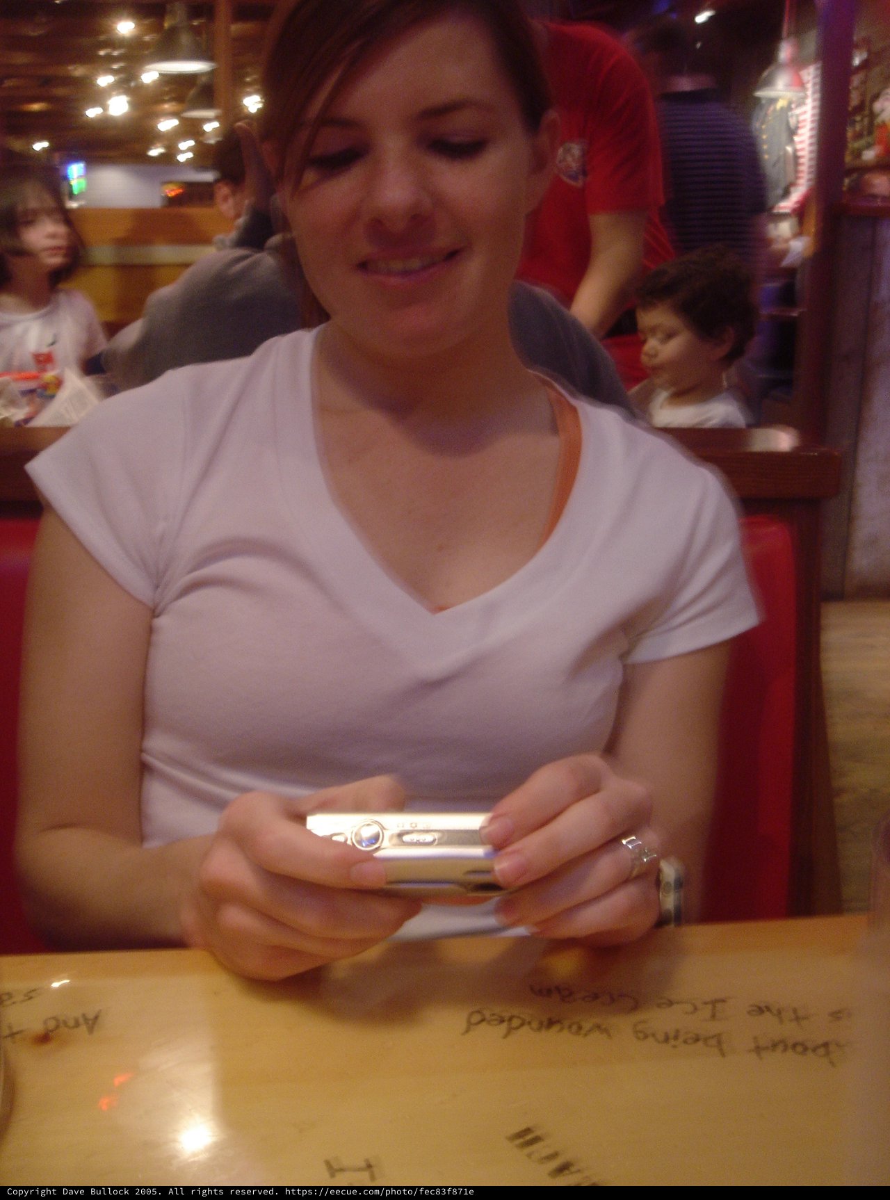 Woman Smiling at Digital Camera in Restaurant Booth