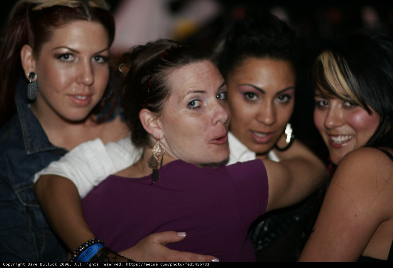 Four Friends Crowding Together at Nightclub Party