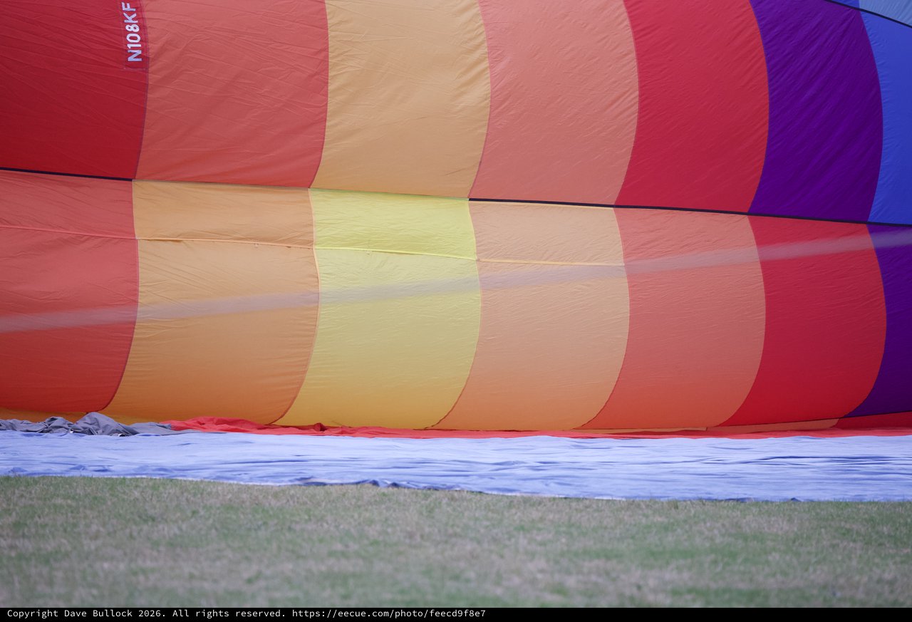 Rainbow Hot Air Balloon Inflating on Grass Field