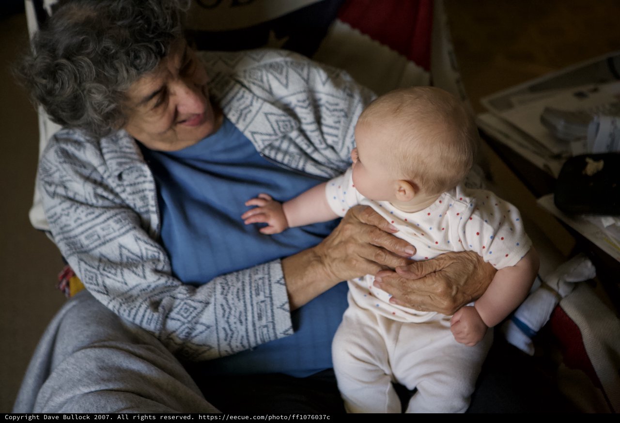 Grandmother's Gentle Hands Cradling New Life