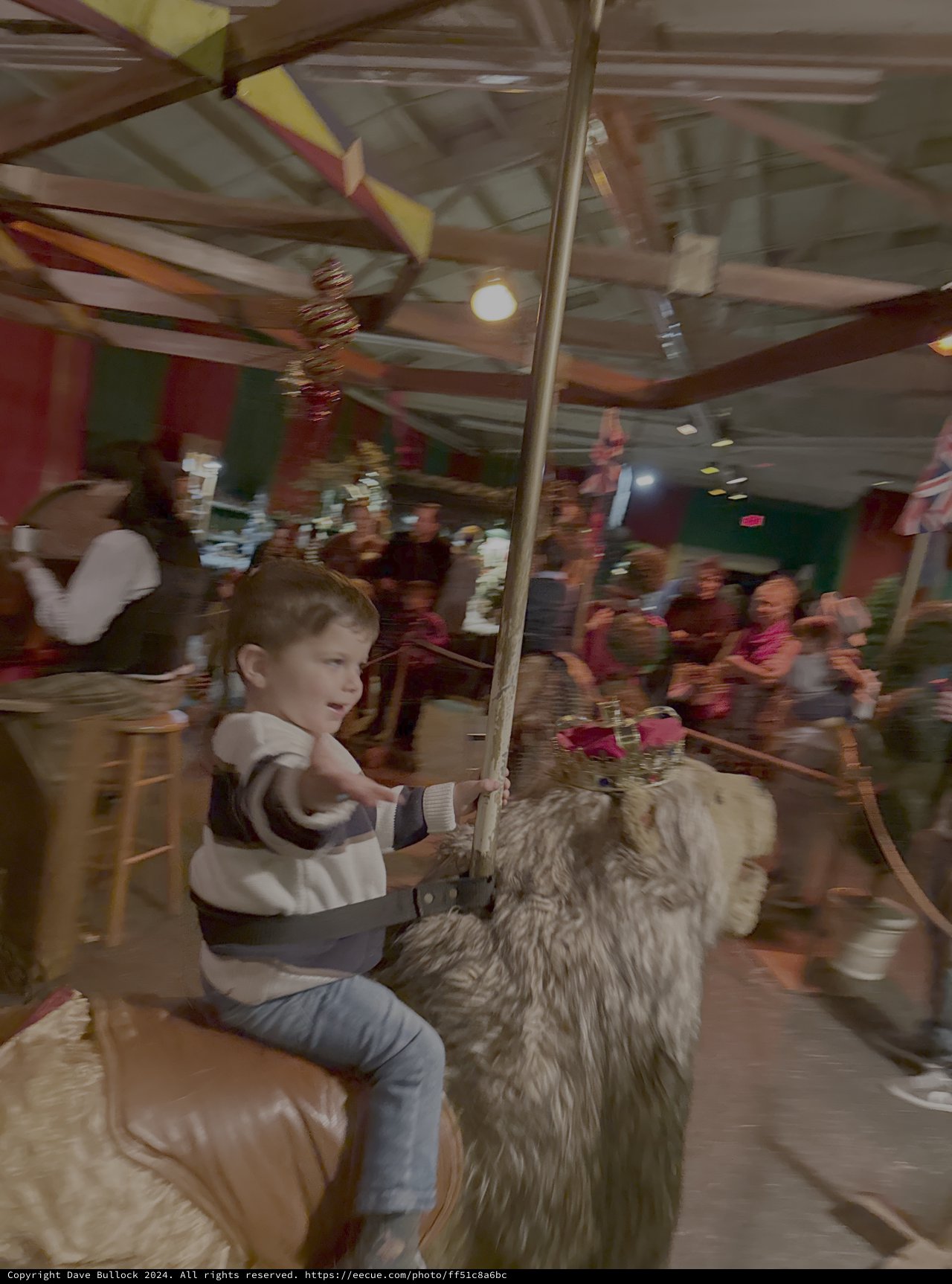 Child Enjoys Carousel Ride on Furry Animal