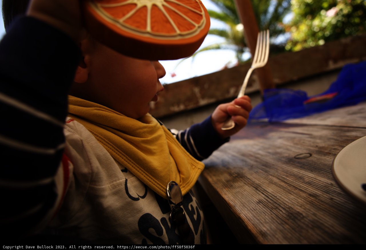 A Zesty Bite: Young Boy with Orange Slice