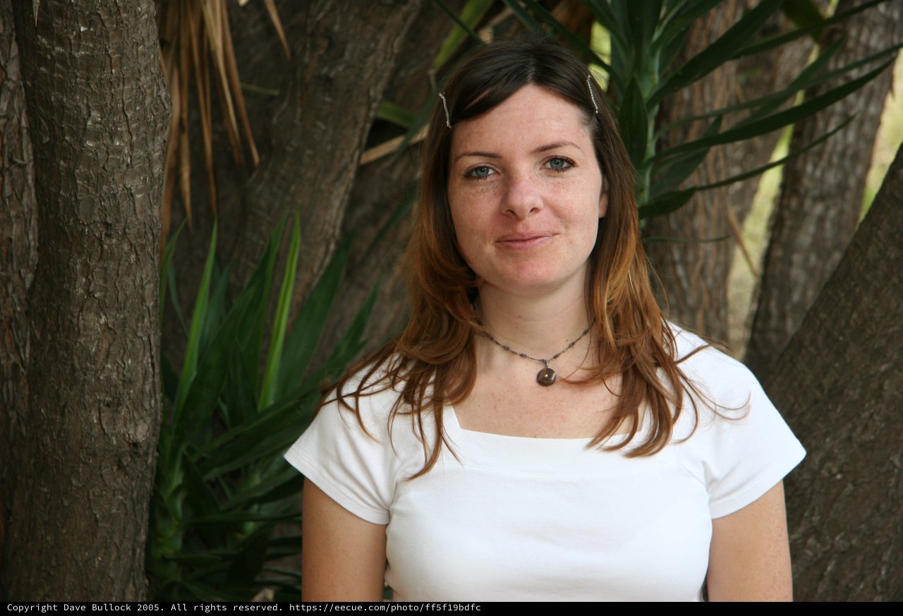 Woman Smiling Outdoors Among Tropical Trees