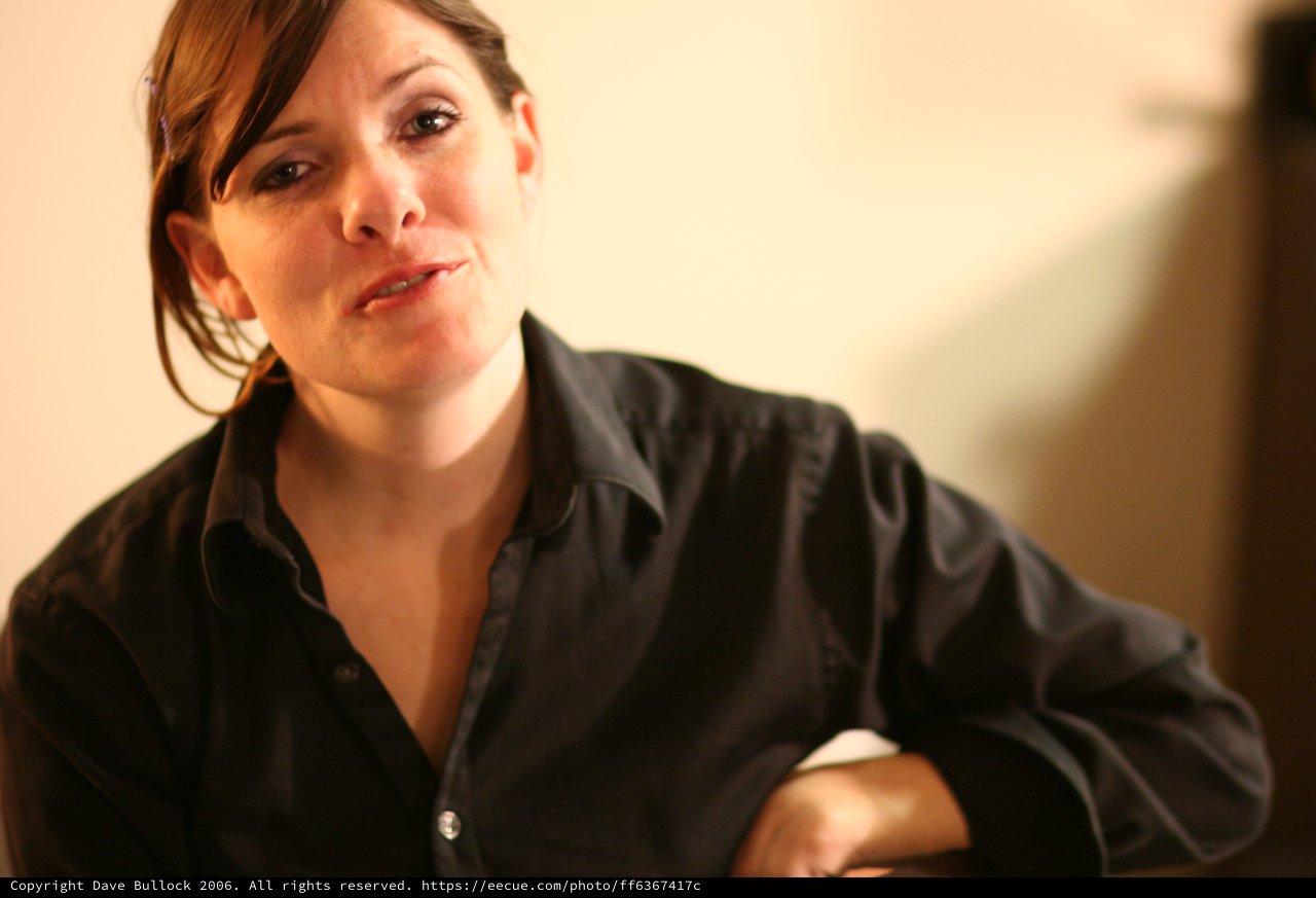 Thoughtful Woman in Black Shirt, Warm Indoor Light